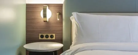 Tête de lit et mobilier bois dans une chambre d’hôtel