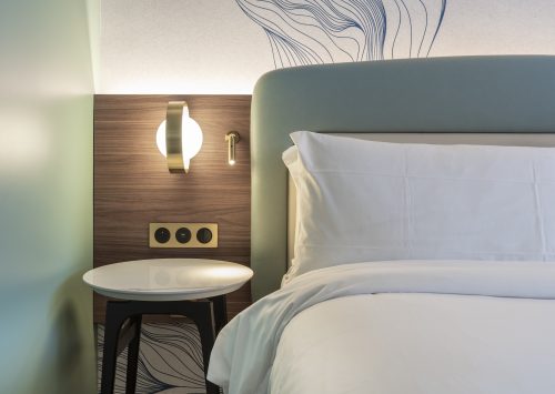 Tête de lit et mobilier bois dans une chambre d’hôtel