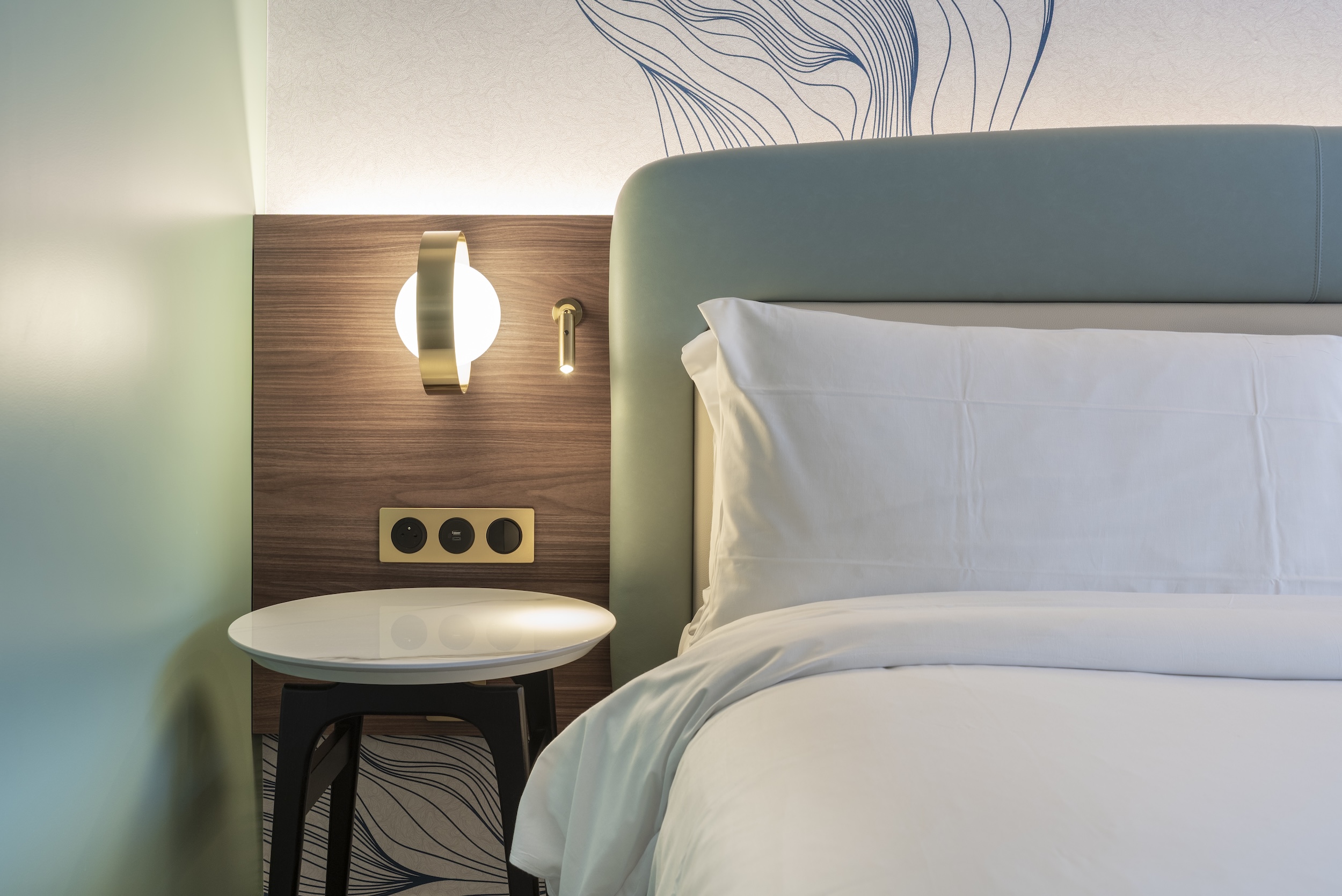 Tête de lit et mobilier bois dans une chambre d’hôtel