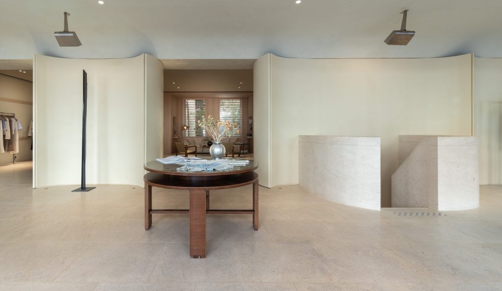 Intérieur de la boutique Frame Cannes avec mobilier premium, lignes courbes et ambiance retail minimaliste