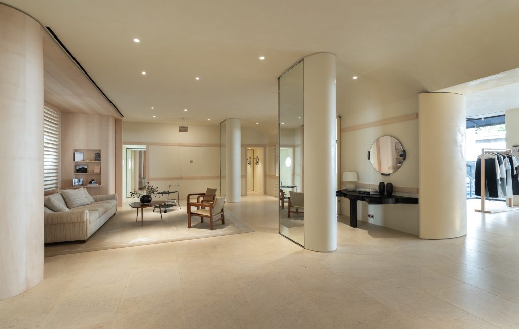 Vue large de la boutique Frame Cannes avec espace salon, miroirs, portants et mobilier sur mesure