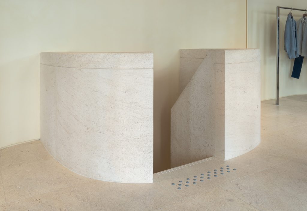 Escalier courbe en pierre de la boutique Frame Cannes avec garde-corps sculptural
