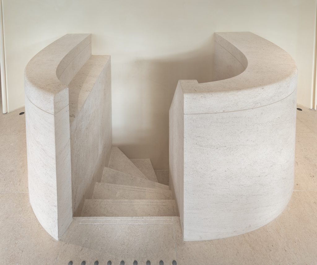Vue plongeante sur l’escalier courbe en pierre de la boutique Frame Cannes