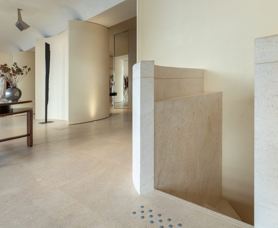 Escalier en pierre de la boutique Frame Cannes avec cloisons courbes et finitions minérales