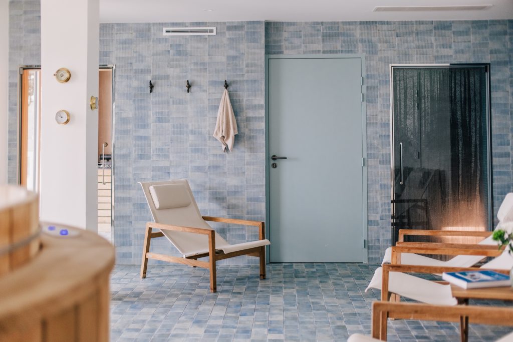 Espace bien-être de l’hôtel Les Bassans avec carrelage bleu, fauteuils et ambiance spa