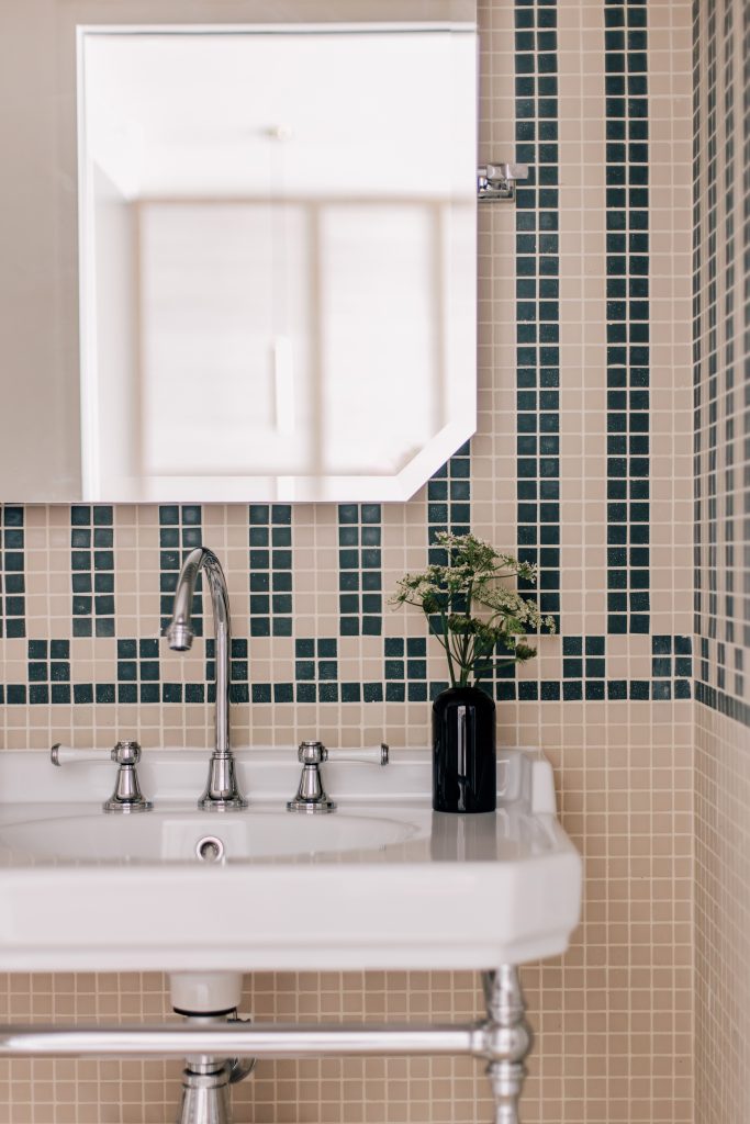 Salle de bain Les Bassans avec vasque blanche, miroir et mosaïque murale beige et bleue