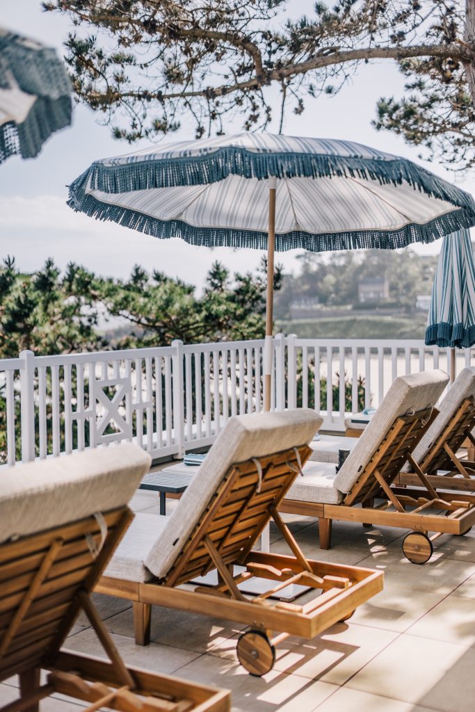Transats et parasol sur la terrasse de l’hôtel Les Bassans face à la mer
