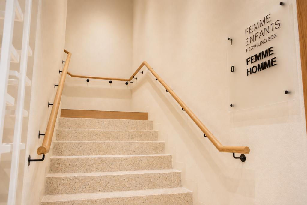 Escalier de la boutique Mango Caen avec signalétique femme, enfants, homme et mains courantes bois