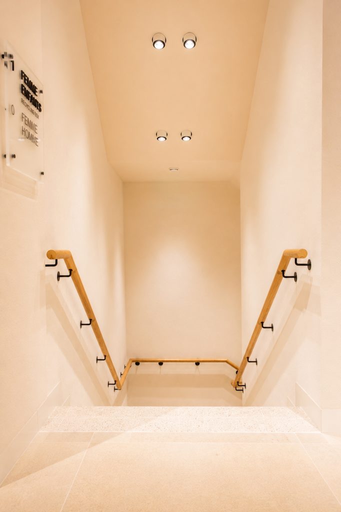 Vue plongeante de l’escalier Mango Caen New Med avec mains courantes bois et éclairage intégré