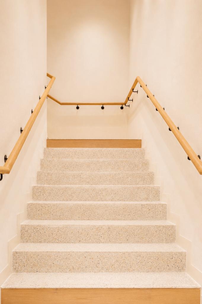 Escalier clair de la boutique Mango Caen New Med avec marches minérales et mains courantes bois