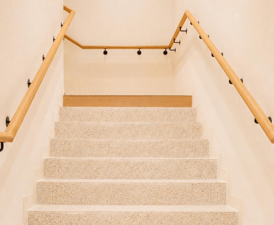 Escalier clair de la boutique Mango Caen New Med avec marches minérales et mains courantes bois