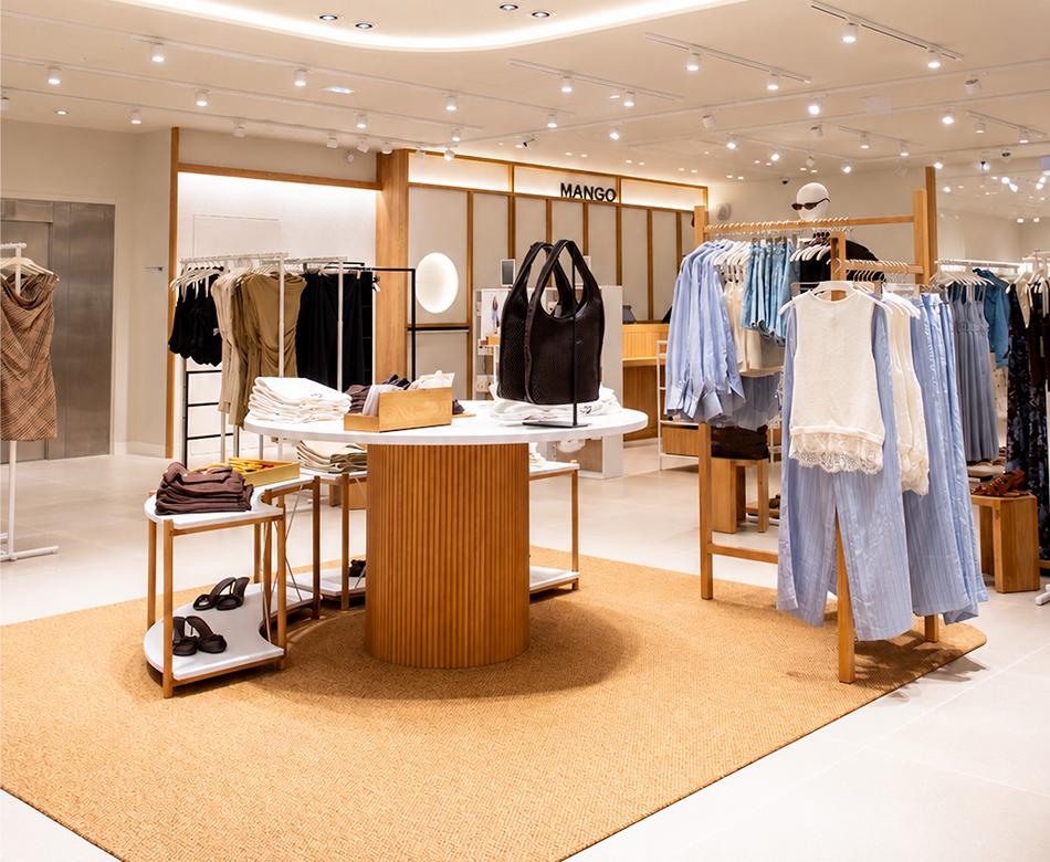 Boutique Mango Caen avec mobilier bois, plafond lumineux arrondi, vêtements et espace de vente New Med