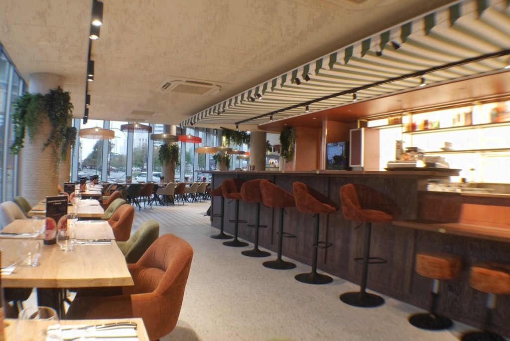 Salle du restaurant Jordan Tomas Pizza à Nantes avec tables, banquettes et comptoir bar sous plafond rayé