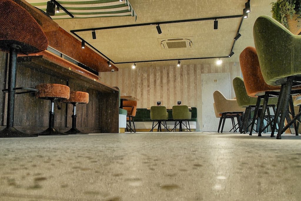 Sol effet terrazzo et mobilier sur mesure avec banquettes et assises colorées du restaurant Jordan Tomas Pizza à Nantes