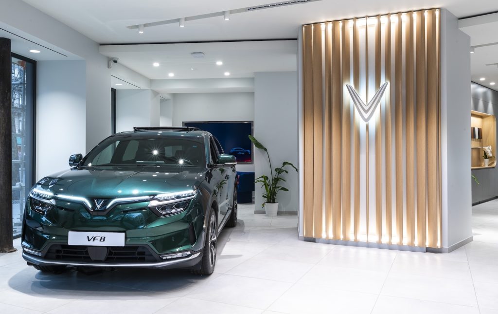 Agencement du showroom VinFast avec SUV électrique et habillage mural lumineux