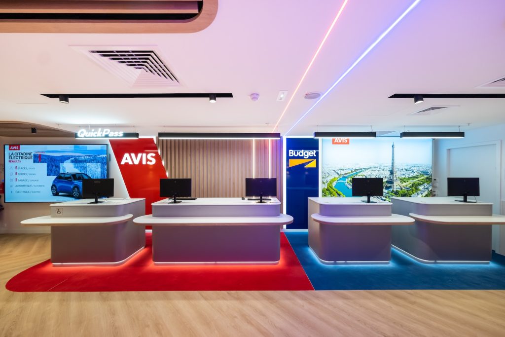 Agencement d’une agence de location Avis et Budget avec comptoirs d’accueil sur mesure