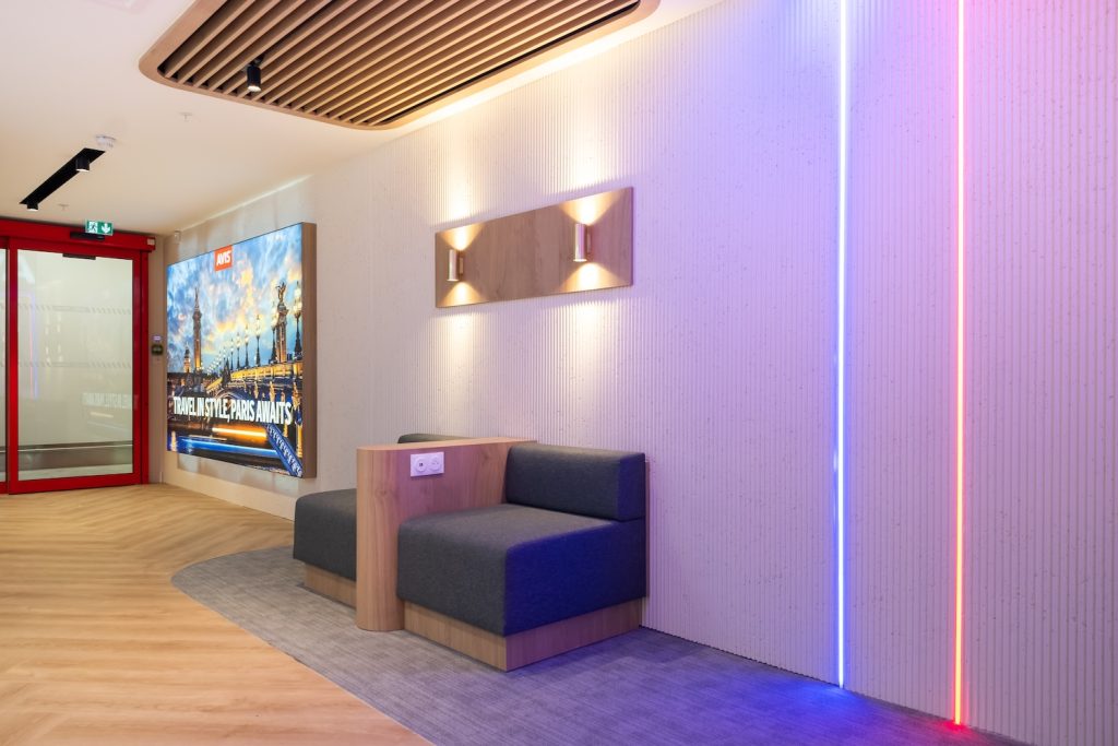 Espace lounge d’une agence Avis avec banquette intégrée et éclairage décoratif